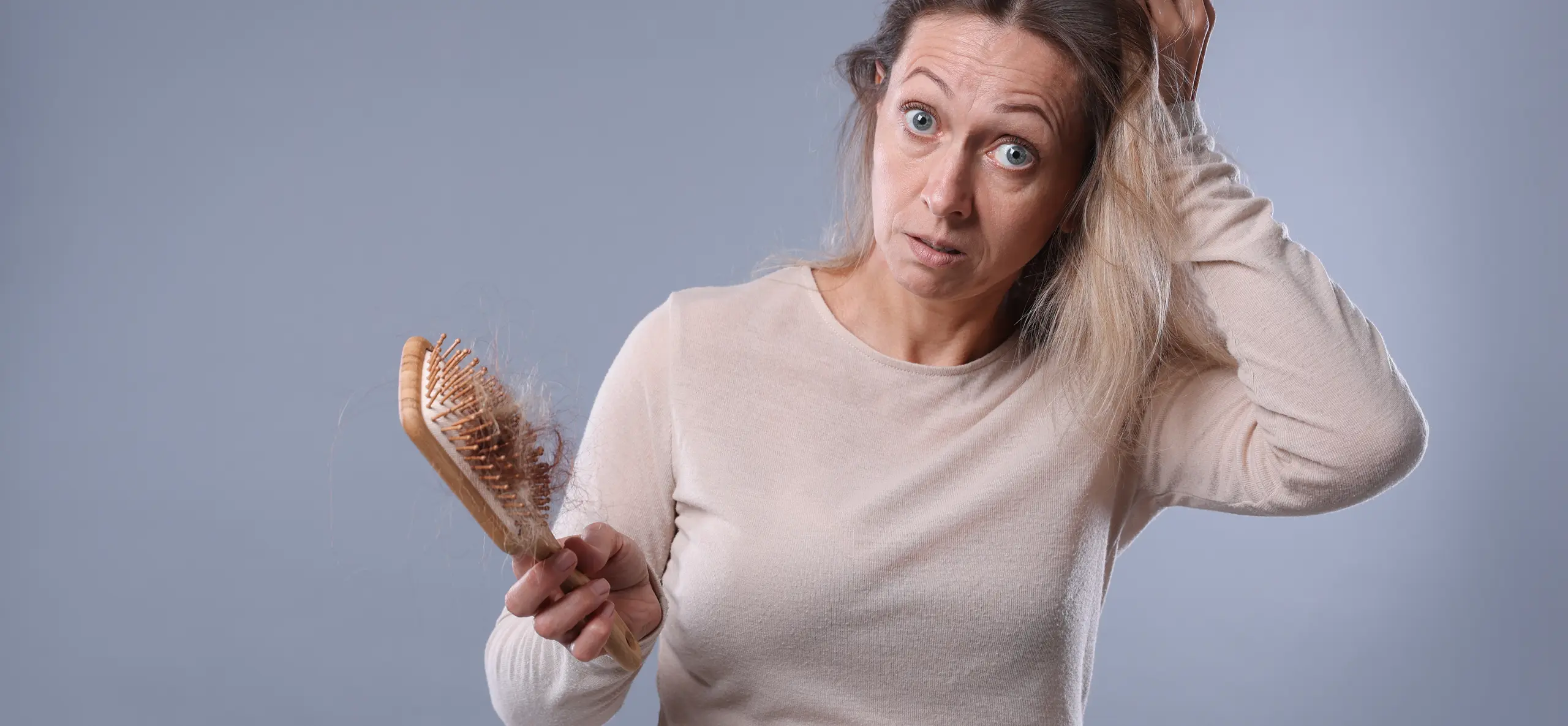 Woman with hair loss holding brush